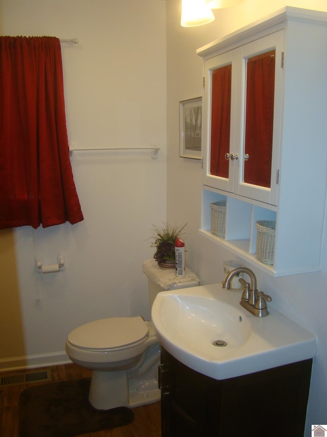 bathroom featuring hardwood / wood-style flooring, vanity, and toilet