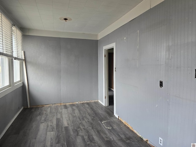 empty room featuring plenty of natural light and dark hardwood / wood-style flooring