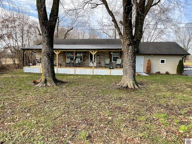 back of house featuring a lawn and covered porch