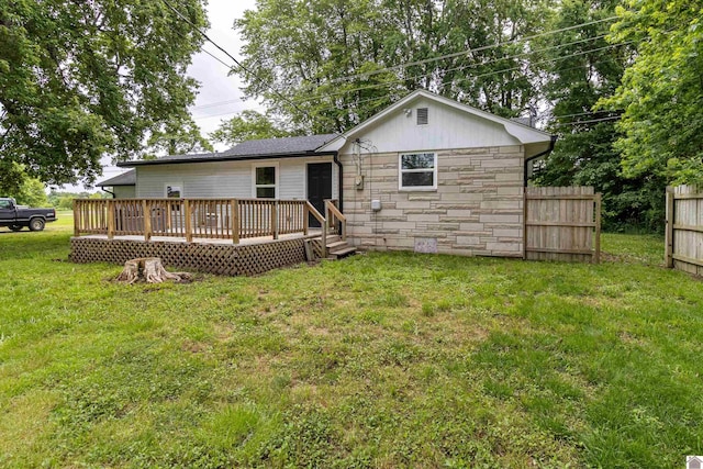 back of property with a yard and a wooden deck