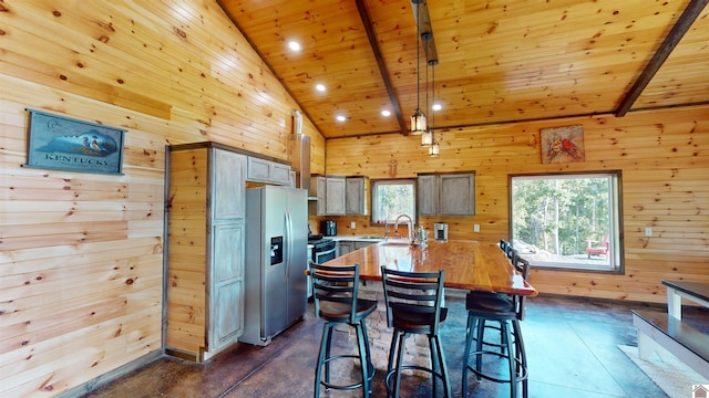 kitchen featuring wood ceiling, stainless steel refrigerator with ice dispenser, and wooden walls