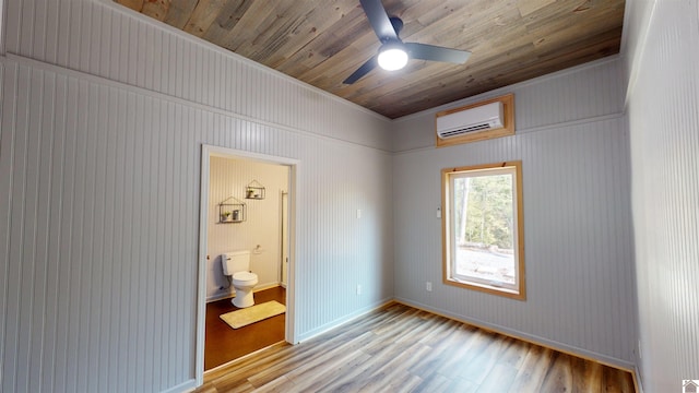 bedroom with light wood-type flooring, ensuite bath, wood ceiling, a wall mounted AC, and ceiling fan