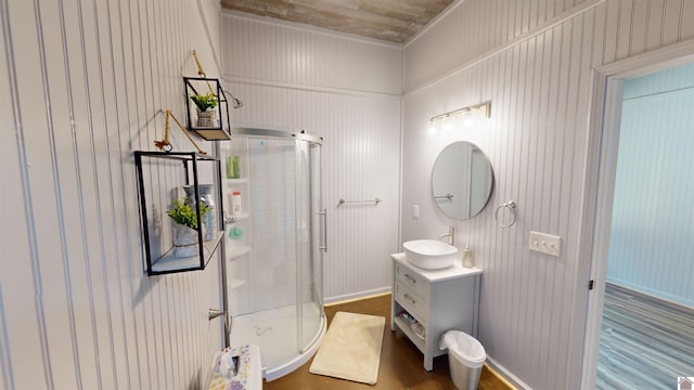 bathroom with hardwood / wood-style floors, vanity, walk in shower, and wooden walls