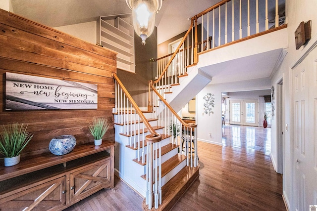 stairway with hardwood / wood-style flooring, a towering ceiling, and french doors