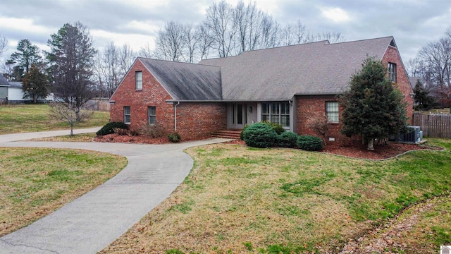 view of front of property with central AC unit and a front lawn