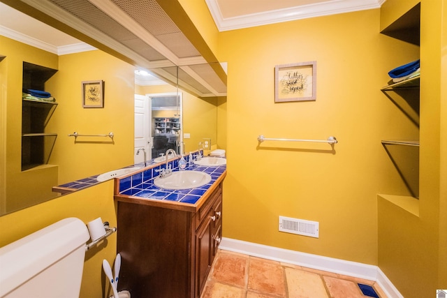 bathroom with toilet, vanity, and ornamental molding