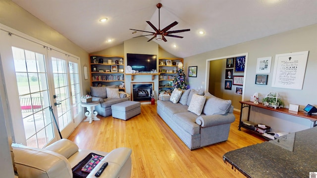 living room with lofted ceiling, ceiling fan, light wood-type flooring, and french doors