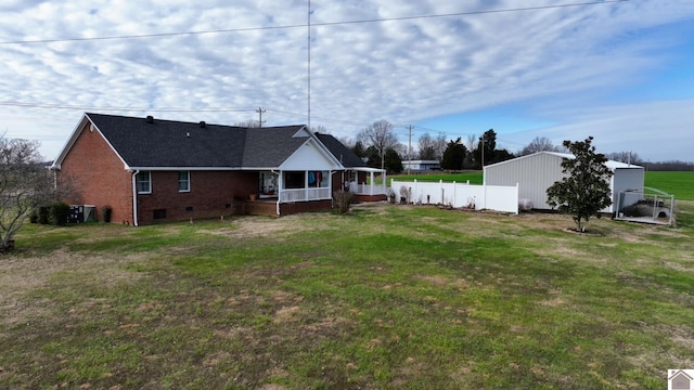 rear view of property featuring a lawn and cooling unit