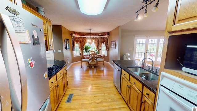 kitchen with pendant lighting, french doors, sink, light hardwood / wood-style floors, and stainless steel appliances