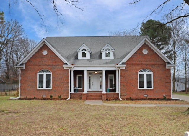 cape cod house featuring a front lawn