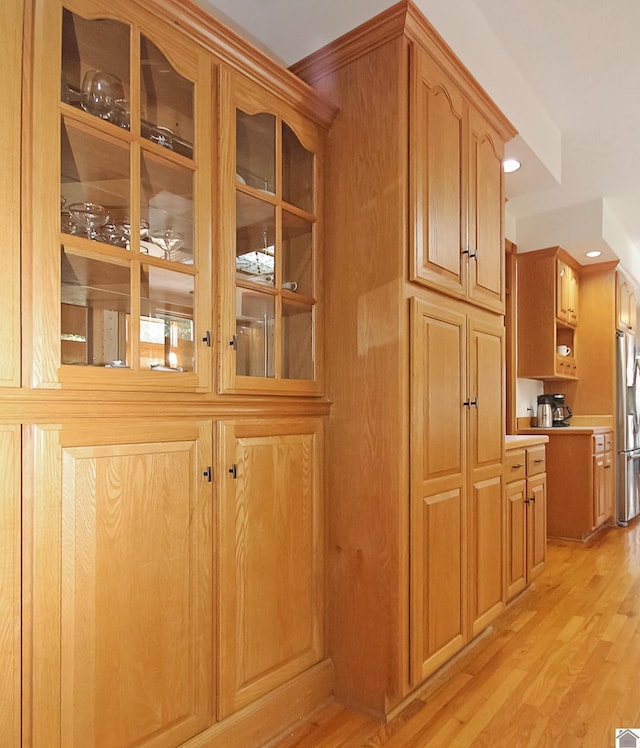 room details featuring stainless steel refrigerator with ice dispenser and hardwood / wood-style flooring