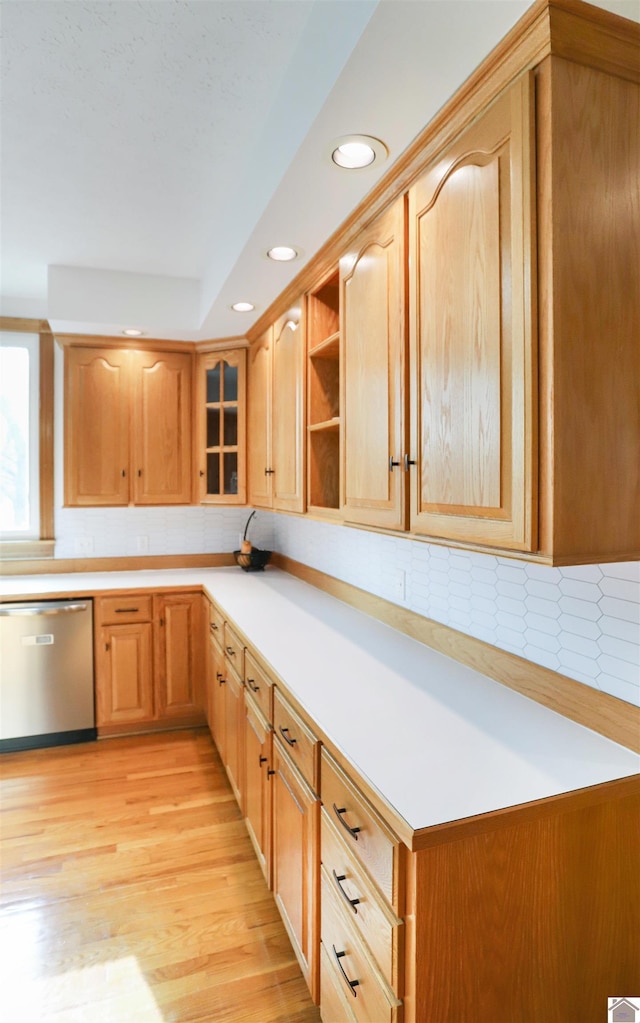 kitchen featuring dishwasher, backsplash, and light hardwood / wood-style flooring