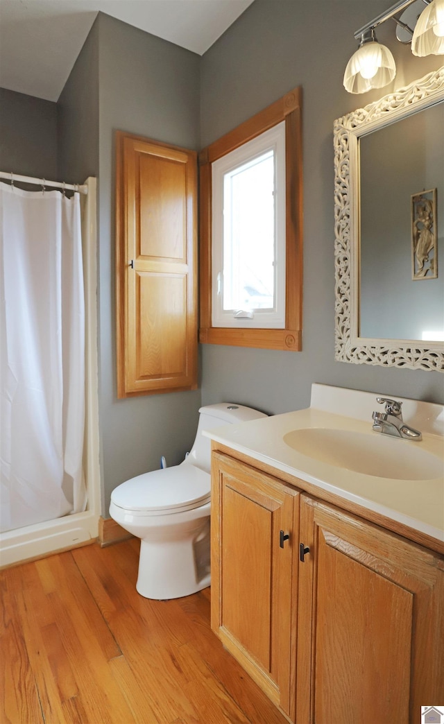 bathroom featuring toilet, vanity, a shower with shower curtain, and hardwood / wood-style flooring