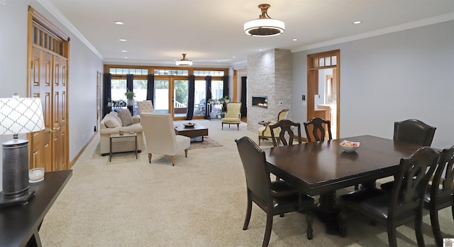 dining room featuring light carpet, french doors, a stone fireplace, and crown molding