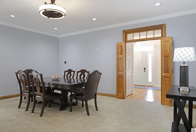 carpeted dining room featuring ornamental molding