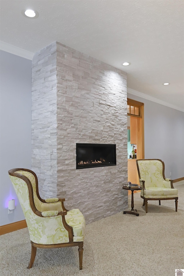 sitting room with ornamental molding, a fireplace, and light carpet