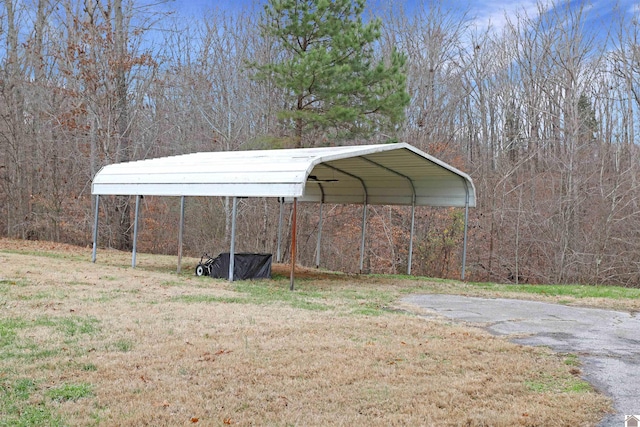 view of parking / parking lot featuring a lawn and a carport