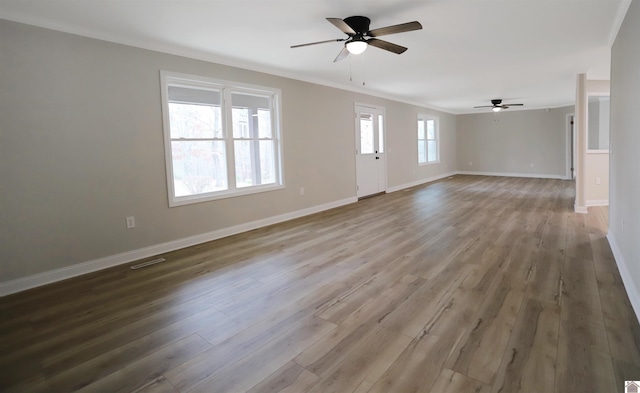 unfurnished living room featuring ceiling fan, ornamental molding, and hardwood / wood-style flooring