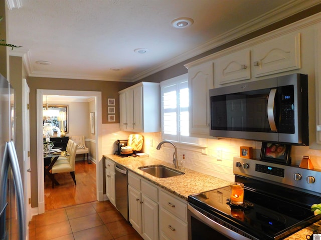 kitchen featuring sink, white cabinets, light tile patterned flooring, and appliances with stainless steel finishes