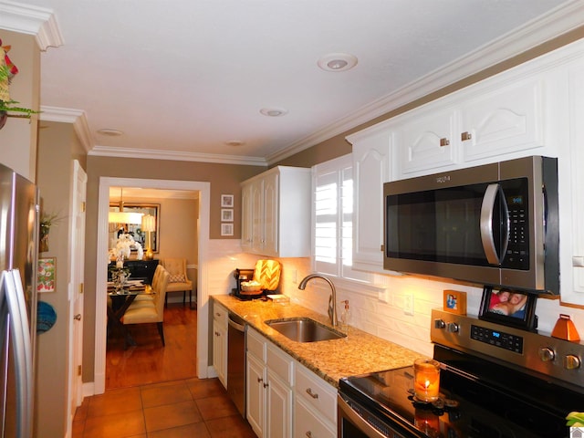 kitchen featuring sink, stainless steel appliances, white cabinets, dark tile patterned flooring, and ornamental molding