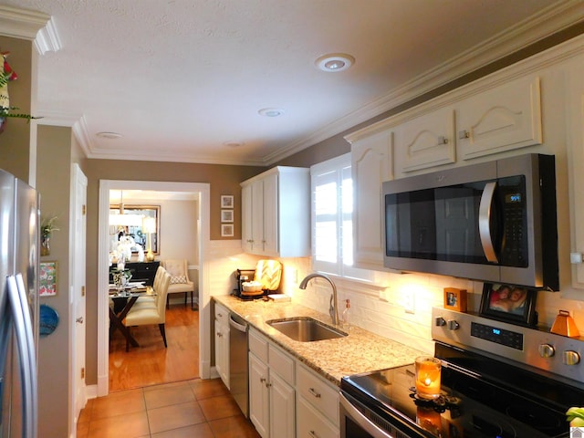 kitchen featuring light tile patterned flooring, appliances with stainless steel finishes, white cabinetry, and sink