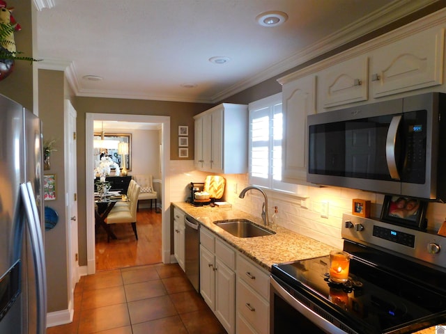 kitchen with sink, stainless steel appliances, light tile patterned floors, crown molding, and white cabinets