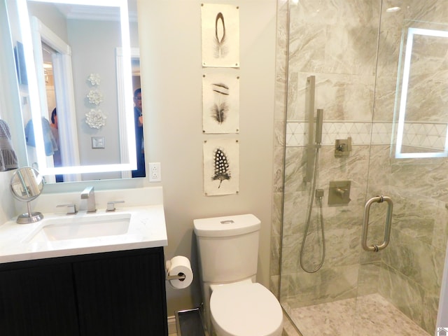 bathroom with a shower with door, vanity, and toilet