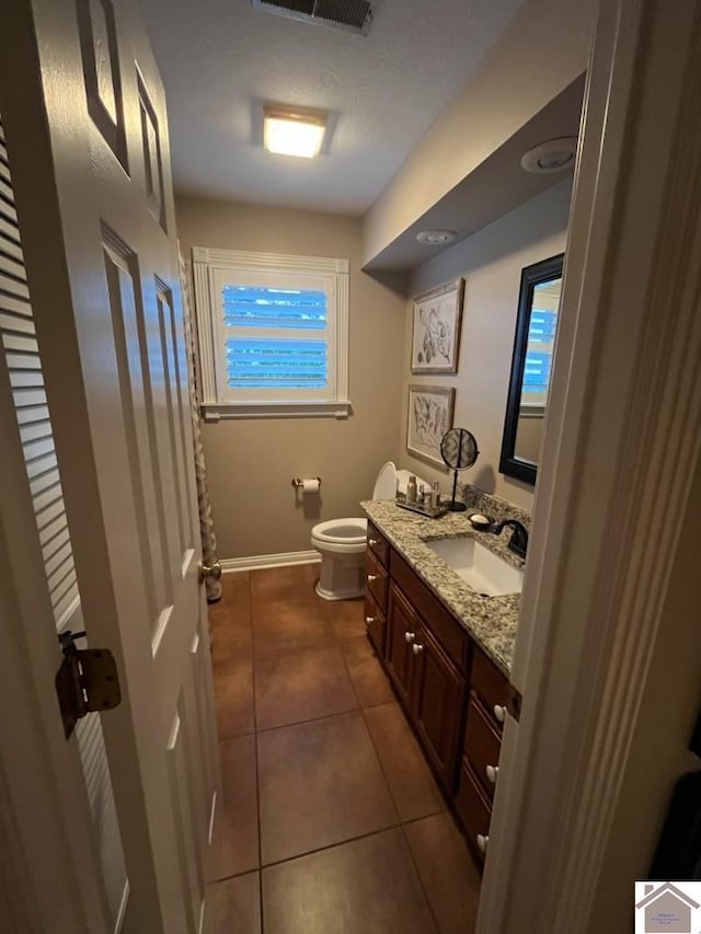 bathroom with tile patterned flooring, vanity, and toilet