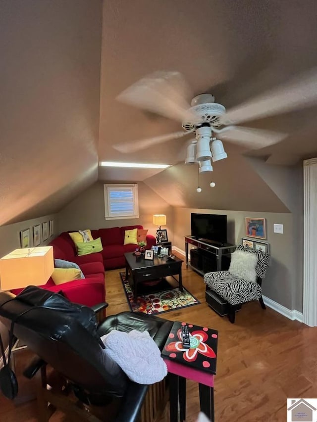 living room with hardwood / wood-style floors, ceiling fan, and vaulted ceiling