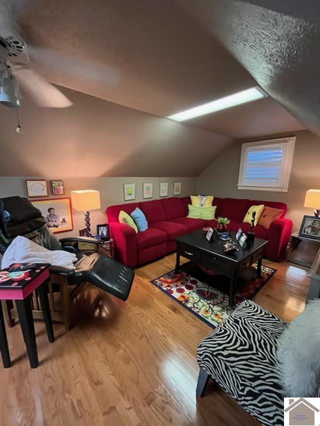 living room featuring light wood-type flooring and vaulted ceiling