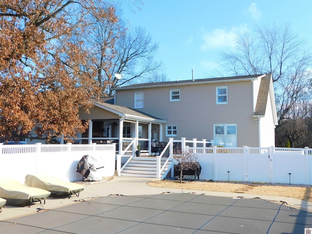 back of house with a sunroom, a pool side deck, and a patio