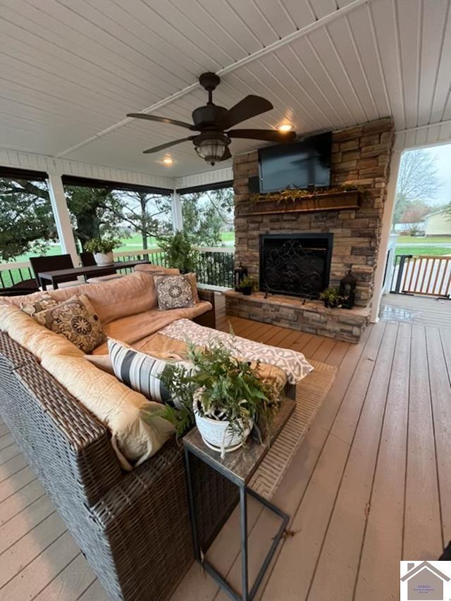 deck featuring an outdoor living space with a fireplace and ceiling fan