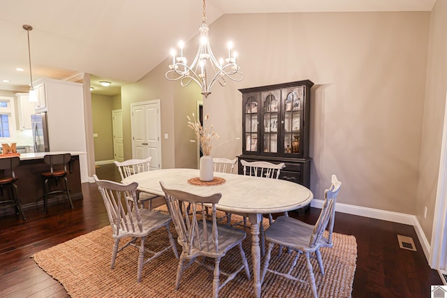 dining room with dark hardwood / wood-style flooring, lofted ceiling, and a notable chandelier