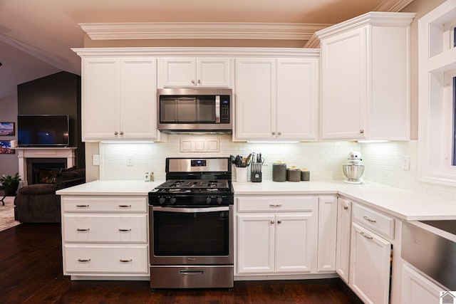 kitchen with tasteful backsplash, dark hardwood / wood-style floors, vaulted ceiling, white cabinets, and appliances with stainless steel finishes