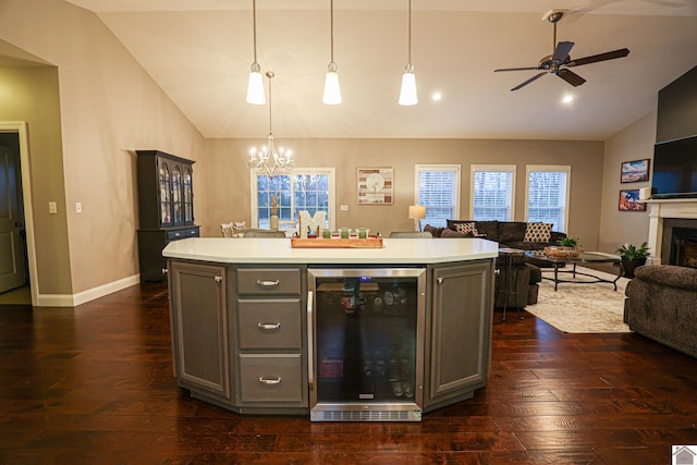 kitchen with gray cabinetry, decorative light fixtures, a center island, and beverage cooler