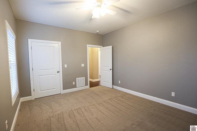 unfurnished bedroom with light colored carpet and ceiling fan