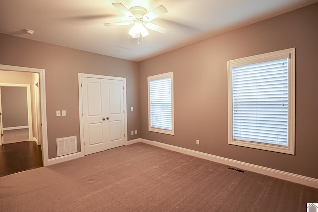 unfurnished bedroom with carpet, ceiling fan, and a closet