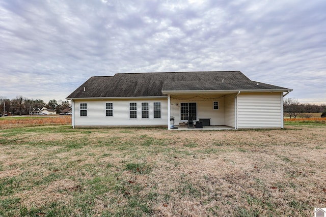 back of property featuring a patio and a lawn