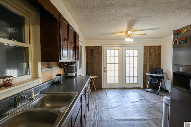 kitchen with stainless steel refrigerator with ice dispenser, dark brown cabinets, a textured ceiling, ceiling fan, and sink