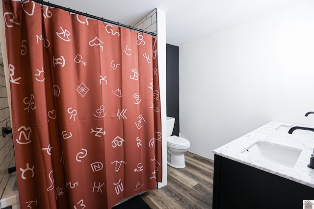 bathroom featuring hardwood / wood-style floors, vanity, curtained shower, and toilet