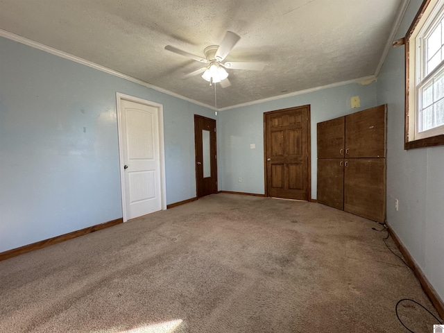 unfurnished bedroom with ceiling fan, carpet floors, a textured ceiling, and ornamental molding