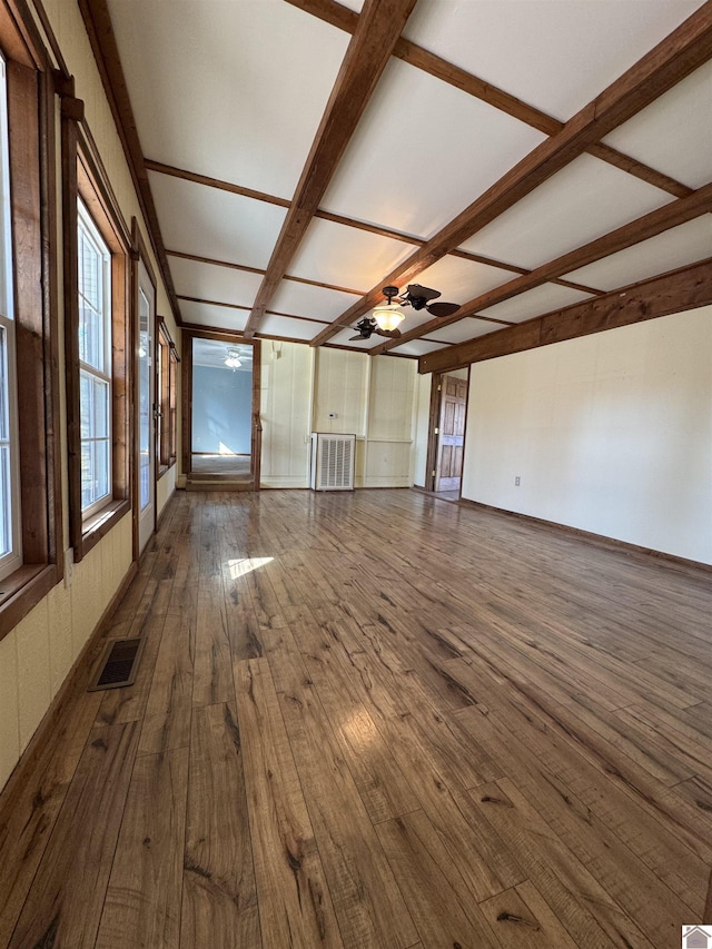 unfurnished living room featuring ceiling fan, beam ceiling, and dark hardwood / wood-style flooring