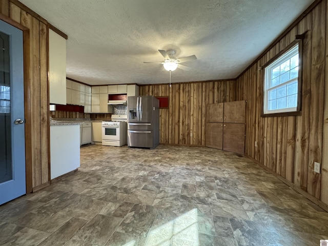 kitchen featuring stainless steel fridge with ice dispenser, ceiling fan, white range with gas cooktop, and wood walls