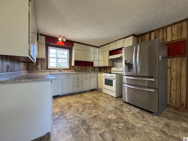 kitchen with sink, stainless steel refrigerator with ice dispenser, white gas range, a textured ceiling, and ornamental molding