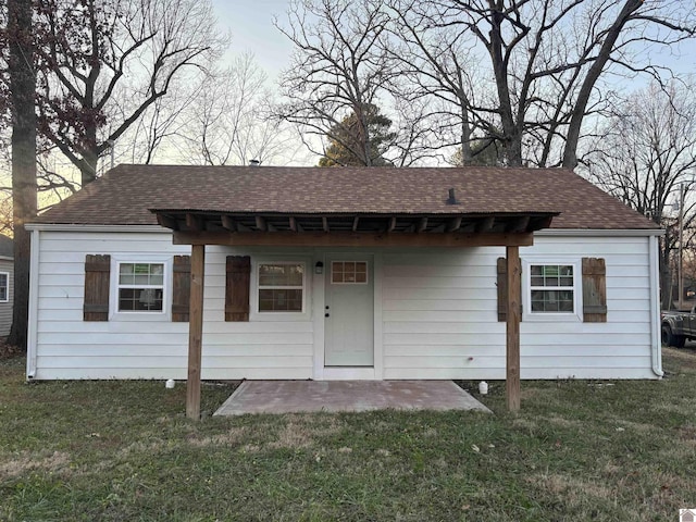 back of property featuring a patio and a lawn