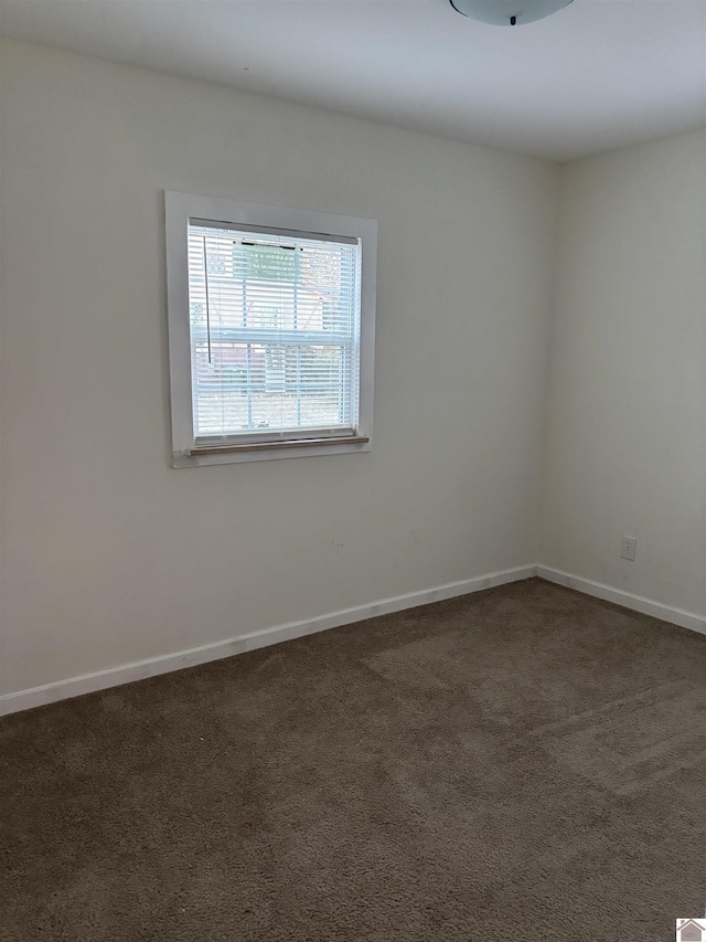 unfurnished room featuring dark colored carpet