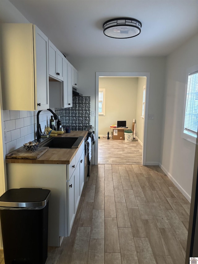 kitchen featuring sink, white cabinetry, wood counters, and tasteful backsplash