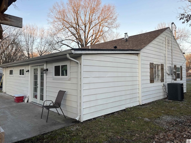 view of side of property featuring central air condition unit, french doors, and a patio