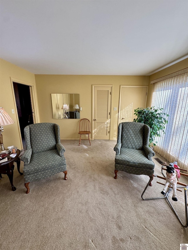 sitting room featuring light colored carpet