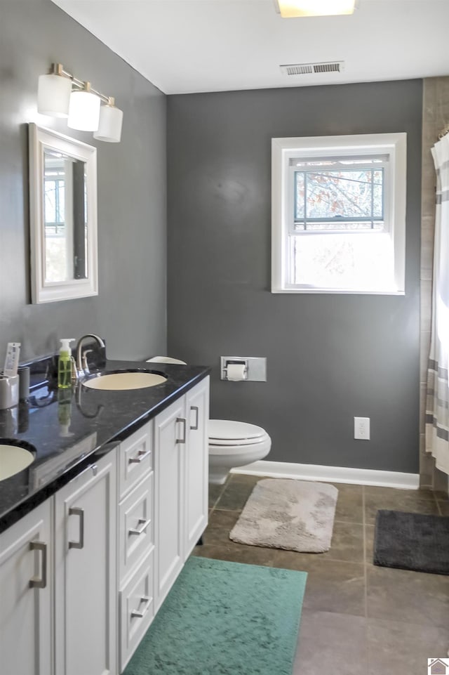 bathroom with tile patterned flooring, a shower with curtain, vanity, and toilet